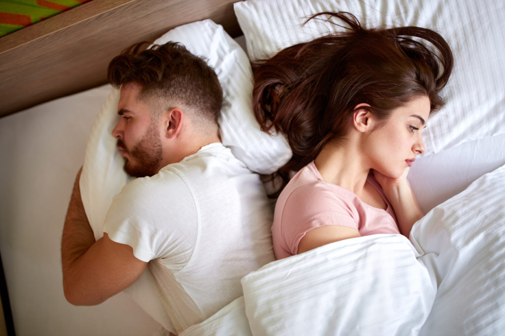 Falta de atenção no relacionamento:  casal na cama triste