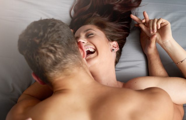 Qualidade de vida sexual: casal feliz juntos brincando na cama 